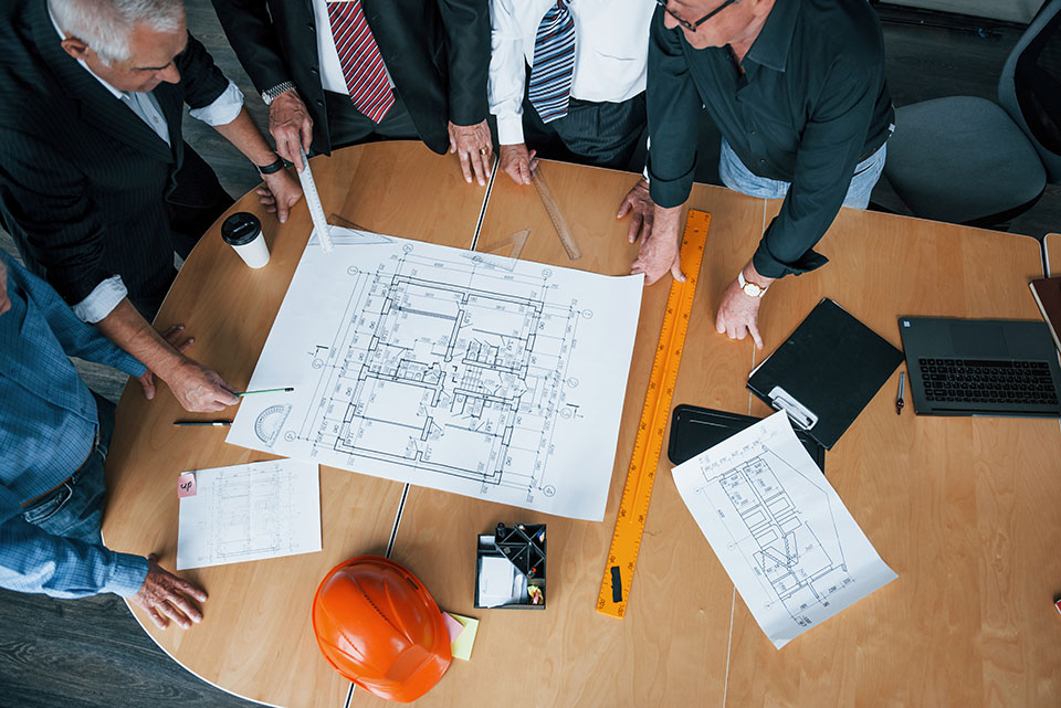 Top view of aged team of elderly businessman architects have a meeting in the office and works with plan.